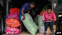 သီရိလင်္ကာနိုင်ငံ ကိုလံဘိုမြို့က ဈေးတခုမှာ ကုန်ချနေတဲ့ အလုပ်သမားတဦး(မတ် ၂၁၊ ၂၀၂၃)