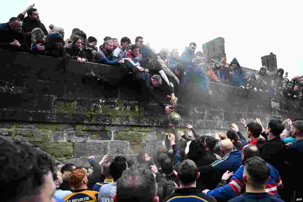 Competitors from the Up&#39;ards and the Down&#39;ards fight for the ball during the annual Royal Shrovetide Football Match in Ashbourne, northern England.