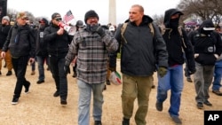 Proud Boys, incluido Joseph Biggs, al frente a la izquierda, caminan hacia el Capitolio de EEUU en Washington, el 6 de enero de 2021.