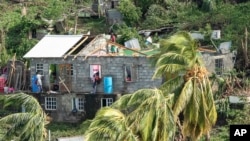 Family members begin to repair their home damaged in the passing of Hurricane Beryl, in Ottley Hall, St. Vincent and the Grenadines, July 2, 2024.