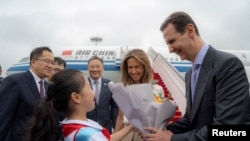 Syria's President Bashar al-Assad and his wife Asma are welcomed upon their arrival at Hangzhou airport, China, Sept. 21, 2023.