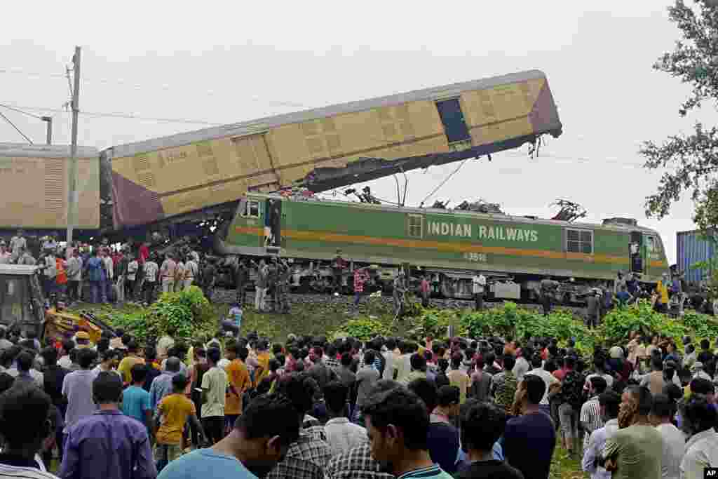 Onlookers watch as rescuers work after a cargo train rammed into Kanchanjunga Express, a passenger train, near New Jalpaiguri station, West Bengal state, India.