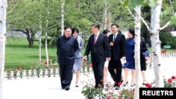 FILE - North Korean leader Kim Jong Un walks with Chinese President Xi Jinping during Xi's visit in Pyongyang, North Korea, in this picture released by by North Korea's Korean Central News Agency (KCNA), June 21, 2019.