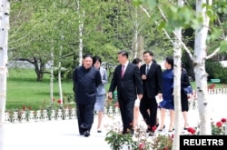 Pemimpin Korea Utara Kim Jong Un berjalan bersama Presiden China Xi Jinping selama kunjungan Xi di Pyongyang, Korea Utara, 21 Juni 2019. (Foto: KCNA via REUTERS)