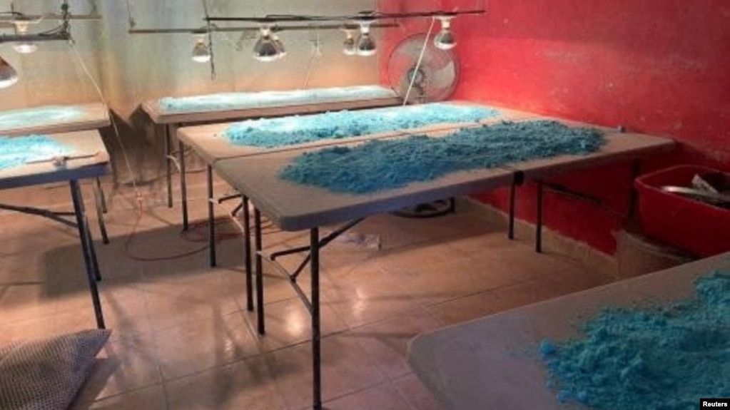 FILE - Blue powder is pictured over tables at a fentanyl pill manufacturing center and a methamphetamine lab seized by the Mexican army in Culiacan, in Sinaloa state, Mexico, Feb. 14, 2023.