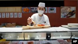 FILE - A sushi chef prepares a plate at the Toyosu Market, Jan. 29, 2024, in Tokyo.