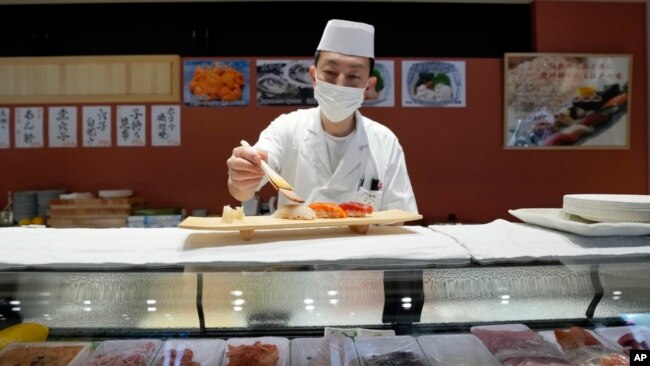 FILE - A sushi chef prepares a plate at the Toyosu Market, Jan. 29, 2024, in Tokyo.
