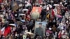 FILE - People attend the Immortal Regiment march through the main street toward Red Square marking the 77th anniversary of the end of World War II, in Moscow, Russia, May 9, 2022. 