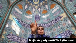 Seorang perempuan Iran menunjukkan jari yang sudah dicelup di tinta dalam pilpres untuk memilih pengganti mendiang Presiden Ebrahim Raisi, di Teheran, Iran, Jumat, 28 Juni 2024. (Foto: Majid Asgaripour/WANA via Reuters)