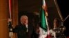 El presidente de México, Andrés Manuel López Obrador, sostiene una campana y la bandera mexicana durante su discurso en el "Grito de Independencia", junto a su esposa Beatriz Gutiérrez Müller, en el Palacio Nacional, en la plaza Zócalo en el centro de la Ciudad de México. 