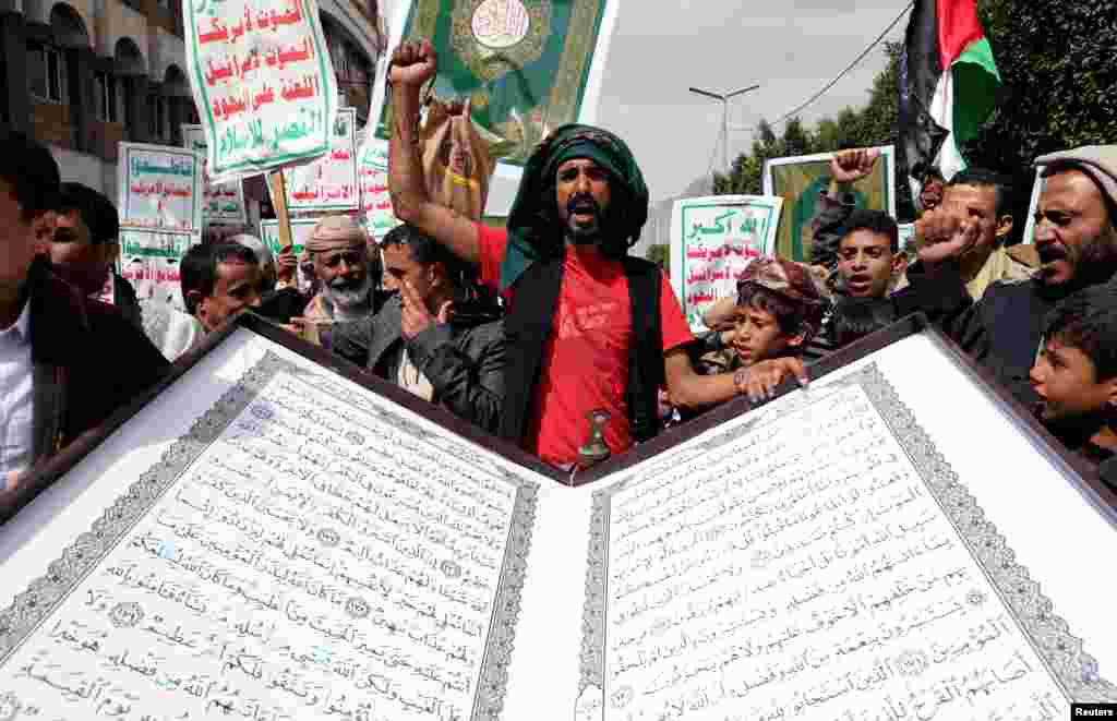 People rally to denounce the burning of the Quran in Sweden and the Israeli military operation in the West Bank city of Jenin, in Sanaa, Yemen.