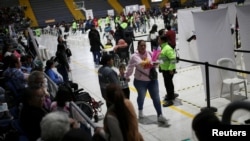 ARCHIVO - Migrantes venezolanos se reúnen durante un día de entregas de Permiso de Protección Temporal (PPT) organizado por Migración Colombia en el Palacio de los Deportes en Bogotá, Colombia, 1 de septiembre de 2023.