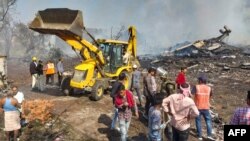 Petugas penyelamat dan penduduk setempat berkumpul di dekat pabrik petasan menyusul ledakan di distrik Harda di negara bagian Madhya Pradesh, India, 6 Februari 2024. (AFP) 