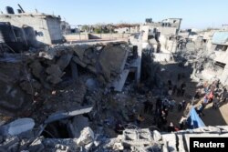 Palestinians inspect the site of an Israeli strike amid the ongoing conflict between Israel and Palestinian Islamist group Hamas, in Rafah in the southern Gaza Strip, Feb. 3, 2024.