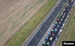 Tractors are lined up during a blockade by farmers on the A4 highway to protest price pressures, taxes and green regulation, grievances that are shared by farmers across Europe, in Jossigny, near Paris, France, Jan. 30, 2024.