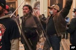 FILE - Rioters, including Dominic Pezzola, center with police shield, are confronted by U.S. Capitol Police officers outside the Senate Chamber inside the Capitol, Jan. 6, 2021