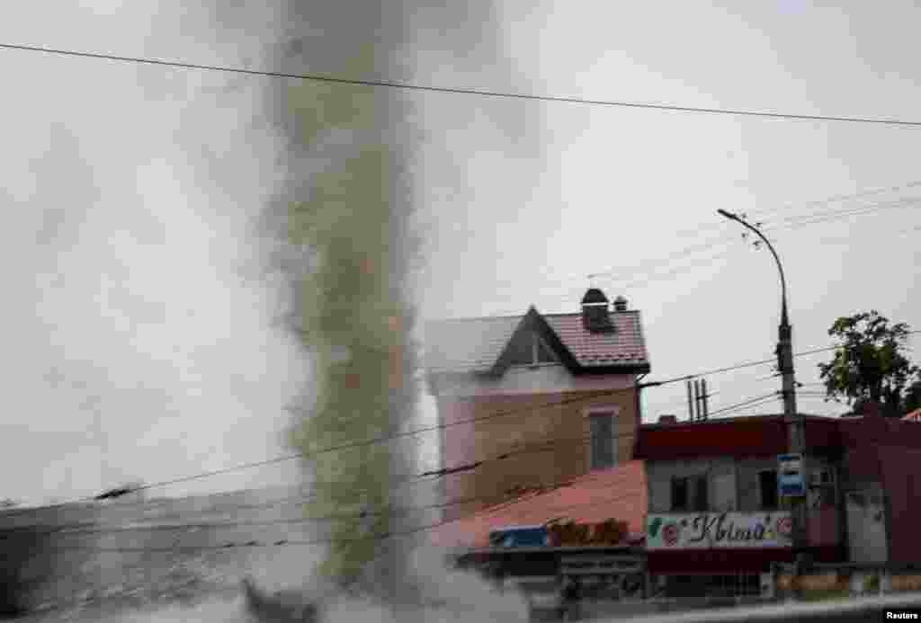 A column of water from the explosion during a Russian military strike is seen during an evacuation of local residents from a flooded area after the Nova Kakhovka dam breached, in Kherson, Ukraine, June 8, 2023.