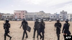 Police officers walk after dispersing protestors during a march calling on authorities to respect the election date, in Dakar, on February 16, 2024.