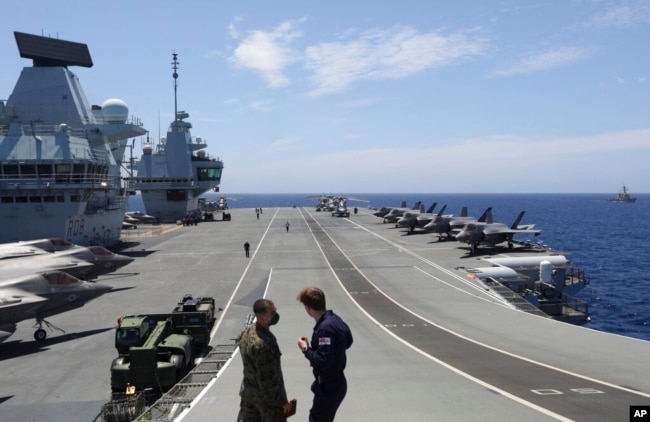 FILE - Military personnel participate in the NATO Steadfast Defender 2021 exercise on the deck of the aircraft carrier HMS Queen Elizabeth off the coast of Portugal, May 27, 2021.