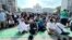 Members of the Pan-Malaysian Islamic Party wait outside the Palace of Justice, background, as they await the Federal Court's decision on Kelantan state's sharia law criminal enactment, in Putrajaya, Malaysia, Feb. 9, 2024.
