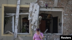 Una mujer habla por su teléfono móvil en el lugar de un ataque con drones rusos, en las afueras de Lviv, Ucrania, el 19 de junio de 2024.