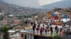 FILE - Tourists take photos in the Comuna 13 neighborhood of Medellin, Colombia, Feb. 2, 2024. 