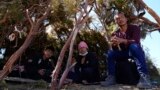 A group of asylum-seekers from Ecuador wait in a makeshift camp after crossing the nearby border with Mexico, Sept. 20, 2023, near Jacumba Hot Springs, Calif. 