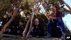 A group of asylum-seekers from Ecuador wait in a makeshift camp after crossing the nearby border with Mexico, Sept. 20, 2023, near Jacumba Hot Springs, Calif. 