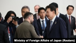 Президент Южной Кореи Юн Сок Ёль пожимает руку президенту Украины Владимиру Зеленскому на встрече G7, стран-партнеров «Большой семерки» и Украины в рамках саммита лидеров G7 в Хиросиме, Япония, 21 мая 2023 года