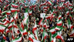 Supporters wave the national flag as they attend a campaign rally by Iranian ultraconservative former nuclear negotiator Saeed Jalili, two days before a presidential election runoff, in Tehran on July 3, 2024. 