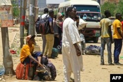 Warga menunggu bus untuk melarikan diri dari Khartoum selatan, 18 April 2023 saat pertempuran antara tentara dan pasukan paramiliter yang dipimpin oleh jenderal saingan berkecamuk untuk hari keempat. (AFP)