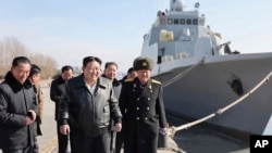 This undated photo provided Feb. 2, 2024, by the North Korean government, North Korean leader Kim Jong Un, center, visits a shipyard in Nampho, North Korea. 