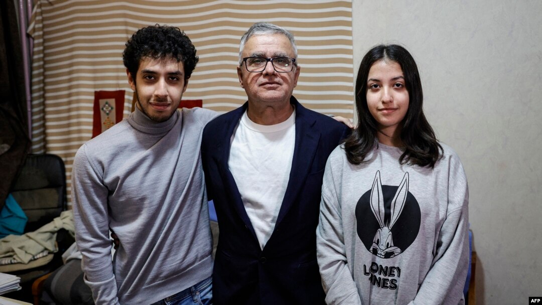 Iranian journalist Taghi Rahmani, center, husband of Iranian rights campaigner and 2023 Nobel Peace Prize laureate Narges Mohammadi, poses with his 17-year-old children, Ali, left, and Kiana during an interview in his apartment in Paris on Dec. 5, 2023. 