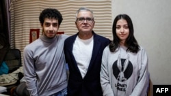 Iranian journalist Taghi Rahmani, center, husband of Iranian rights campaigner and 2023 Nobel Peace Prize laureate Narges Mohammadi, poses with his 17-year-old children, Ali, left, and Kiana during an interview in his apartment in Paris on Dec. 5, 2023. 