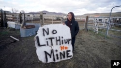 FILE - Daranda Hinkey, a Fort McDermitt Paiute and Shoshone tribe member, holds a sign that reads, 'No Lithium No Mine,' at her home on the Fort McDermitt Indian Reservation, April 24, 2023, near McDermitt, Nev.