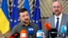 O Presidente ucraniano, Volodymyr Zelenskyy, à esquerda, e o Presidente do Conselho Europeu, Charles Michel, falam com os meios de comunicação social à chegada a uma cimeira da UE em Bruxelas, a 27 de junho de 2024.