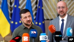 Ukrainian President Volodymyr Zelenskyy, left, and European Council President Charles Michel speak with the media as they arrive for an EU summit in Brussels, June 27, 2024.