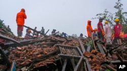 Rescuers work at a site of a landslide triggered by torrential rains in Raigad, western Maharashtra state, India, July 20, 2023. While some people are reported dead, many others are feared trapped under piles of debris.