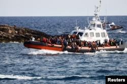 Migrants arrive on an Italian Coast Guard vessel after being rescued at sea, near the Sicilian island of Lampedusa, Italy, Sept. 18, 2023.