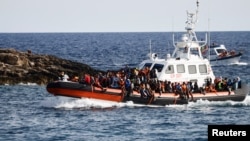 Migrants arrive on an Italian Coast Guard vessel after being rescued at sea, near the Sicilian island of Lampedusa, Italy, Sept. 18, 2023.
