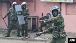 A Kenyan police officer throws a tear gas canister during anti-government protests in Nairobi on July 20, 2023.