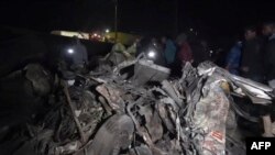 This video grab from AFPTV on June 30, 2023, shows vehicle wreckage after an accident between the towns of Kericho and Nakuru, Kenya. At least 48 people were killed when a truck apparently lost control and struck other vehicles at a busy junction.