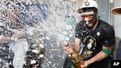 El delantero de los Boston Celtics, Jayson Tatum, rocía champán mientras celebra tras derrotar a los Dallas Mavericks en el quinto partido para ganar las finales de baloncesto de la NBA el lunes 17 de junio de 2024 en Boston. (Elsa/Pool Photo vía AP)