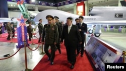 Pemimpin Korea Utara Kim Jon-un (kanan) bersama Menteri Pertahanan Rusia Sergei Shoigu mengunjungi pameran senjata dalam peringatan 70 tahun berakhirnya Perang Korea, 27 Juli 2023. (Foto: KCNA via Reuters)