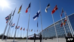 FILE - Finnish military personnel install the Finnish national flag at the NATO headquarters in Brussels, on April 4, 2023.