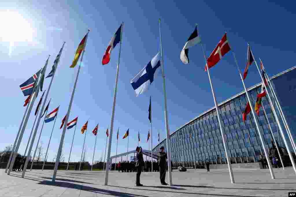 Finnish military personnel install the Finnish national flag at the NATO headquarters in Brussels, as Finland became the 31st member of NATO.