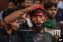 A Kashmiri Shiite Muslim mourns as he flagellates himself during a Muharram procession in Srinagar, Kashmir, on July 27, 2023. Thousands of Shiite Muslims were allowed to hold a religious procession marking the Muslim month of Muharram in Indian-controlled Kashmir's main city for the first time in three decades ago.