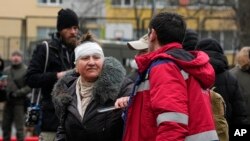 Bolničar pomaže ženi ispred stambene zgrade uništene u ruskom napadu na Kijev, Ukrajina, 7. februara 2024.