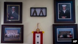 Robert Decker displays photographs to honor the U.S. Navy service of both of his sons, Kyle and Kody, at his home in Norfolk, Virginia, March 14, 2023. Kody Decker committed suicide in October 2022 while stationed at Norfolk Naval Station.