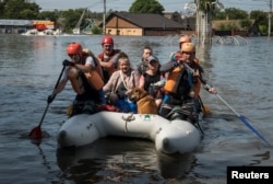 烏克蘭的松卡霍夫卡大壩被炸毀後，烏克蘭救援人員從洪水氾濫的赫爾鬆地區救出民眾。 （2023年6月7日）
